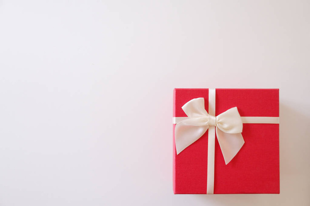 Крупный план красный подарочная коробка с белой лентой на белом фоне
. - Фото, изображение