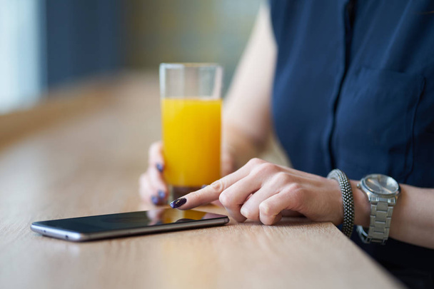 Kädet nainen, käyttämällä älypuhelinta kahvilassa
 - Valokuva, kuva