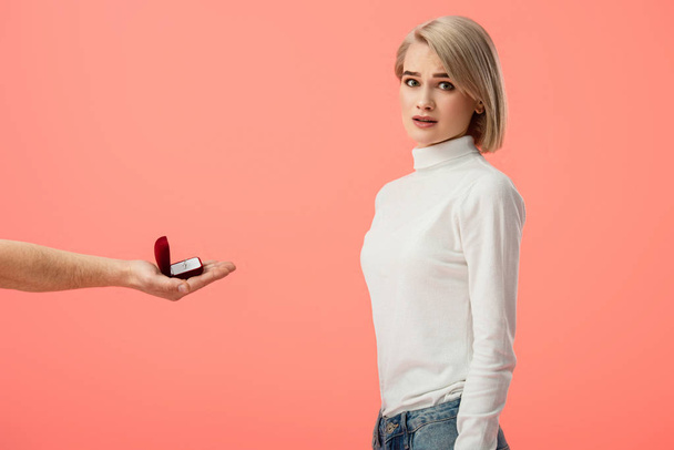 cropped view of man holding box with wedding ring near attractive blonde girlfriend isolated on pink - Фото, зображення