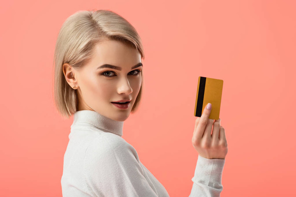 atrakcyjny blond kobieta trzyma karty kredytowej na różowym tle  - Zdjęcie, obraz