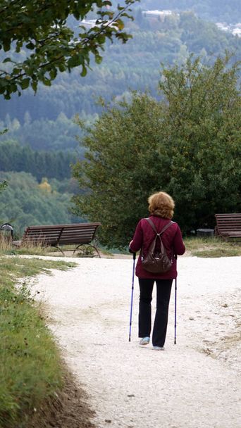 Una mujer que se dedica a caminar nórdico en el parque. Estilo de vida saludable
. - Foto, imagen
