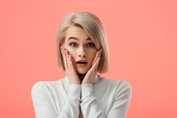 surprised blonde girl looking at camera isolated on pink  - Foto, afbeelding
