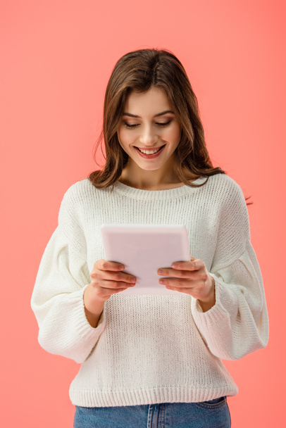 smiling and beautiful young woman holding digital tablet isolated on pink   - Foto, imagen