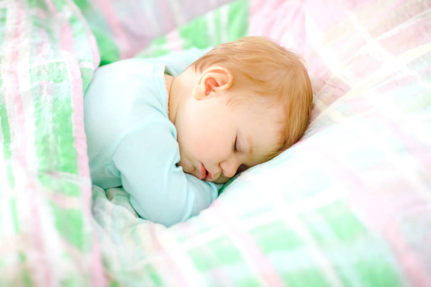 Adorable little baby girl sleeping in bed. Calm peaceful child dreaming during day sleep. Beautiful baby in parents bed. Sleeping together concept. - Photo, Image