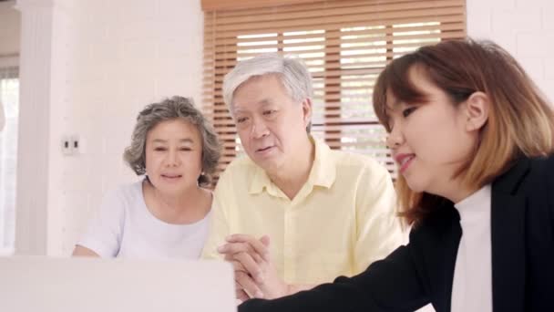 Asia Smart Female agent biedt ziektekostenverzekering voor oudere koppels per document, Tablet en laptop. Leeftijd Aziatische paar Consulting met verzekeringsagent tijdens het zitten samen met thuis. - Video