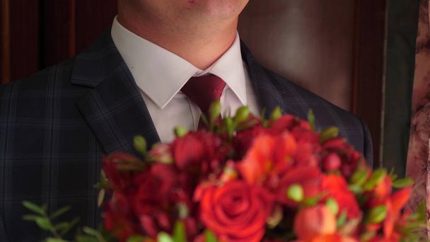 gyönyörű csokor vörös rózsa, kezében a férfiak burkolat piros nyakkendőt és fehér inget. közeli kép: - Fotó, kép