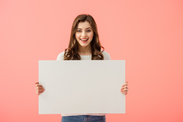 smiling and attractive woman holding empty board with copy space isolated on pink - Фото, изображение