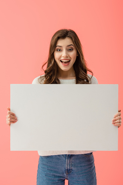 happy and beautiful woman holding empty board with copy space isolated on pink - Фото, изображение
