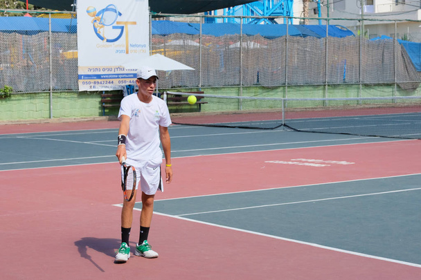 Izrael - Netanya, 27 lipca 2018: gra młodego człowieka w sportowych koszulkę i spodenki sportowe na kort tenisowy w tenisie - Zdjęcie, obraz