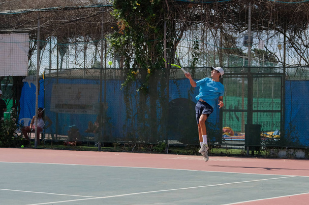 Israël - Netanya, 27 juli 2018: een jonge man in een shirt van de sport en sport shorts speelt op de tennisbaan in tennis - Foto, afbeelding