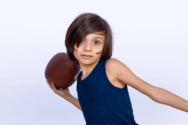 Little boy with american football ball. - 写真・画像