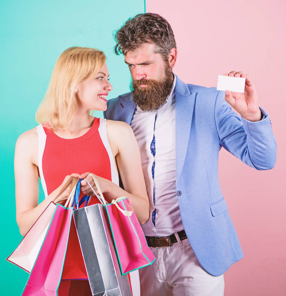 Ask man to purchase lots presents for girlfriend. Paying while dating. Couple with luxury bags in shopping mall. Couple enjoy shopping. Man bearded hipster hold credit card and girl enjoy shopping - Photo, Image