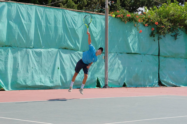israel - netanya, 27. Juli 2018: Ein junger Mann in Sporthemd und Sporthose spielt auf dem Tennisplatz im Tennis - Foto, Bild