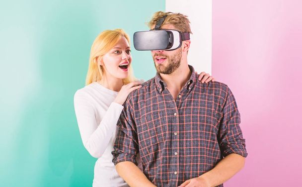 Man VR glasses involved video game while girl try to wake him up. Video game addiction symptoms and treatment. Video game captured imagination of guy. Wife tries to help him back into real life - Foto, imagen