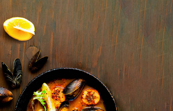 Mussels with sauce in authentic frying pan on wooden background. - Φωτογραφία, εικόνα