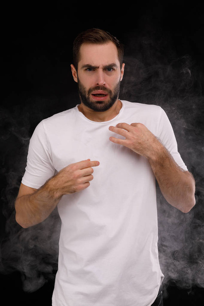 The guy in the white T-shirt choking on smoke - Foto, imagen