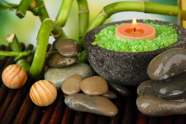 Still life with green bamboo plant and stones, on bamboo mat, on bright background - Photo, Image