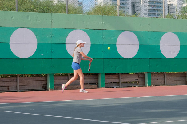 ISRAELE - Netanya, 27 luglio 2018: una giovane ragazza gioca a tennis con una camicia sportiva in pantaloncini sportivi corre intorno al campo batte la palla esegue il deposito al torneo in Israele
 - Foto, immagini