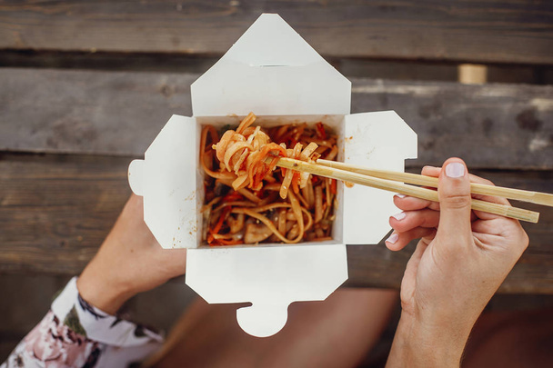 Fille manger des nouilles wok avec des légumes et des fruits de mer en carton bo
 - Photo, image