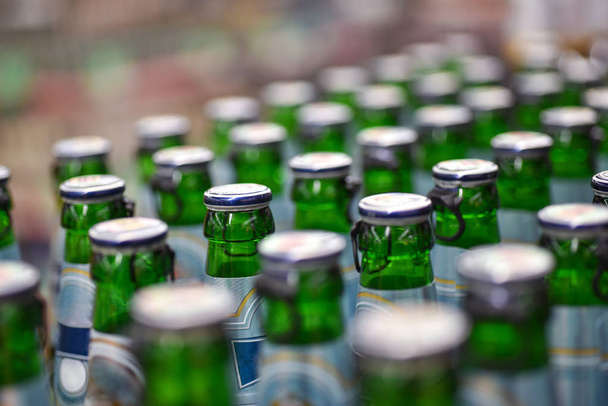 Garrafas de cerveja de plástico no transportador de fábrica
 - Foto, Imagem