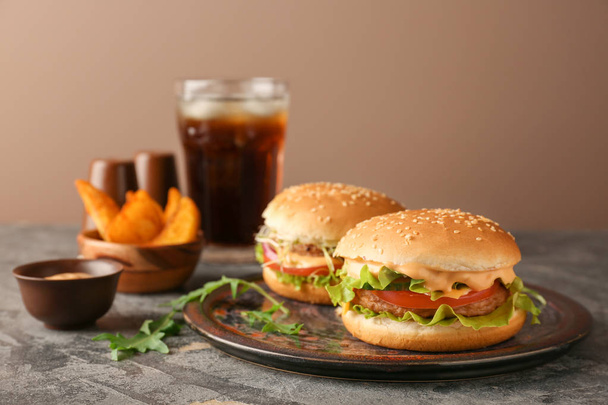 Plate with tasty burgers on table - Valokuva, kuva