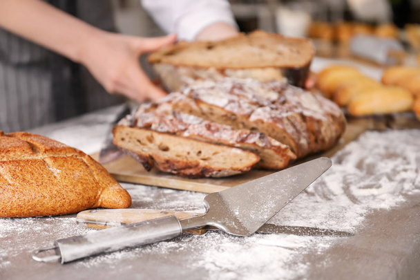Utensilios con pan recién horneado en la mesa en la cocina
 - Foto, imagen