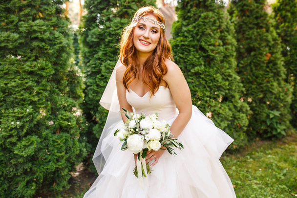 beautiful bride in white wedding dress posing outdoor - Foto, Imagen