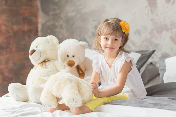 Portrait of child girl having fun sitting and playing with a ted - Фото, зображення