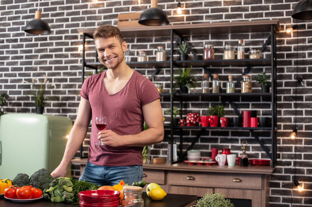 Handsome man wearing jeans and t-shirt cooking healthy dinner for wife - Zdjęcie, obraz