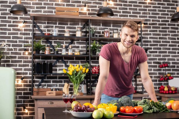 Handsome bearded boyfriend smiling while standing in the kitchen - Fotografie, Obrázek