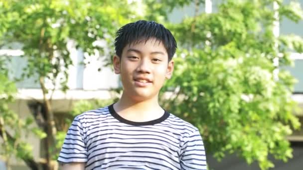 4 k ハンドヘルド、ダンスし水と遊ぶ、それを楽しんでアジアの少年の肖像非常に水で入浴。少年は自宅の庭で非常に幸せと笑顔をします。. - 映像、動画
