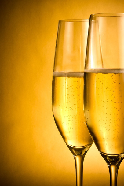 two flutes of champagne with golden bubbles and space for text - Fotó, kép