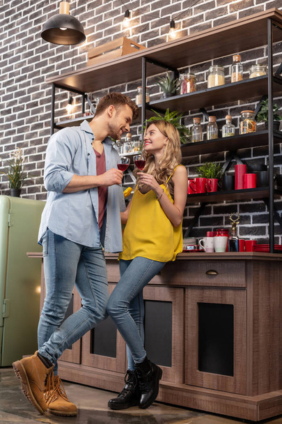 Just married couple wearing stylish casual clothes drinking wine at home - Photo, image