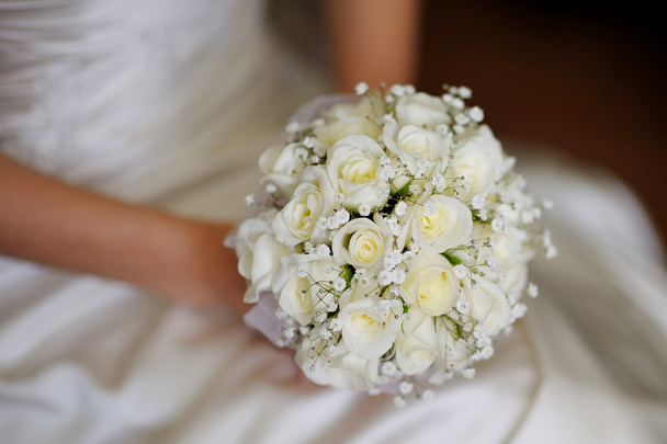 Boeket van witte rozen in handen van de bruid de bruiloft - Foto, afbeelding