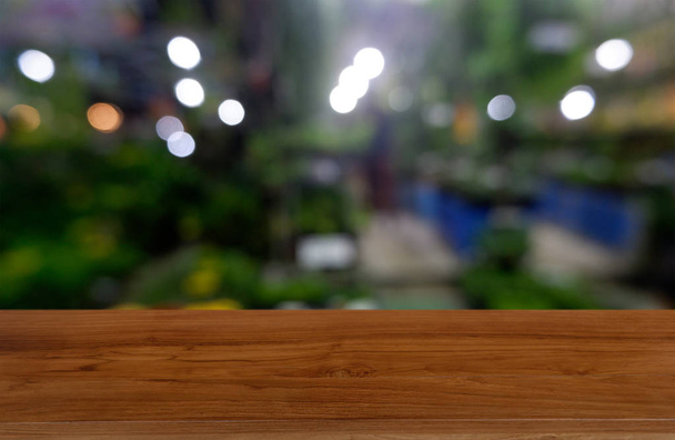 Empty wooden table in front of abstract blurred green of garden. - Photo, Image