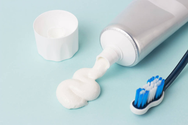 Зубна паста в трубці і зубна щітка на синьому фоні. Концепція гігієни зубів
. - Фото, зображення