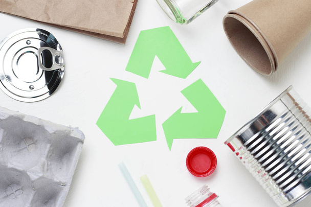 Green recycle garbage symbol and plastic, iron garbage on white background, top view. - 写真・画像
