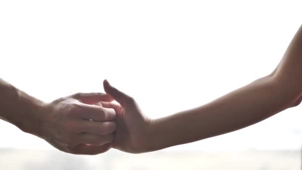 Close up of a man and woman hands and arms having a thumb war with their fingers in front of a window with lots of bright white sunlight coming through the glass. - Footage, Video