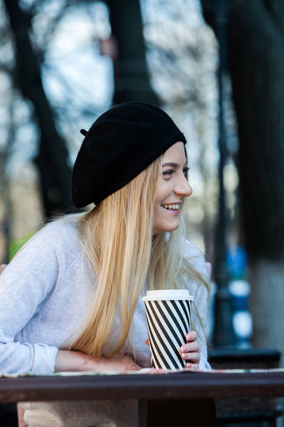 Hermosa mujer sosteniendo taza de café de papel en la ciudadJoven mujer elegante beber café para ir en una calle de la ciudad
  - Foto, imagen