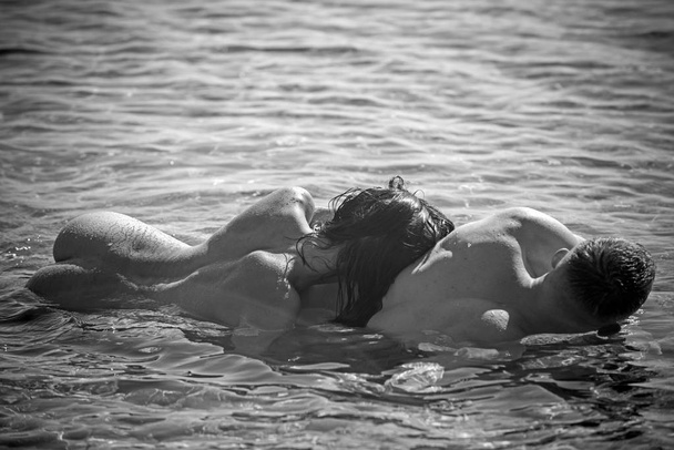 Family and valentines day. Love relations of naked couple in sea water. Summer holidays and paradise travel vacation. Sexy woman and man have sex games. Couple in love with sexy body relax on beach - Fotografie, Obrázek