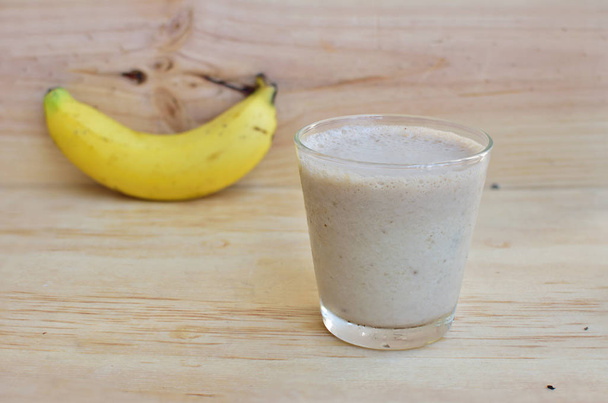 A Glass of fresh banana fruit smoothie on a rustic wooden backgr - Photo, Image