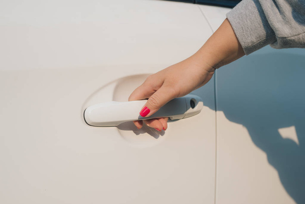 Крупный план женской руки, открывающей дверь машины
  - Фото, изображение