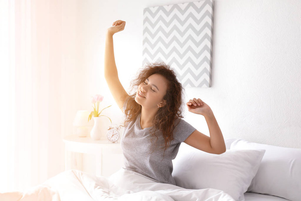 Утро молодой женщины в спальне - Фото, изображение