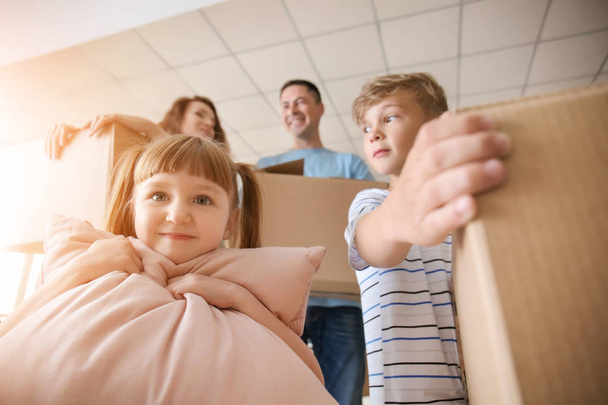 Діти та їхні батьки з картонними коробками після переїзду в новий будинок
 - Фото, зображення
