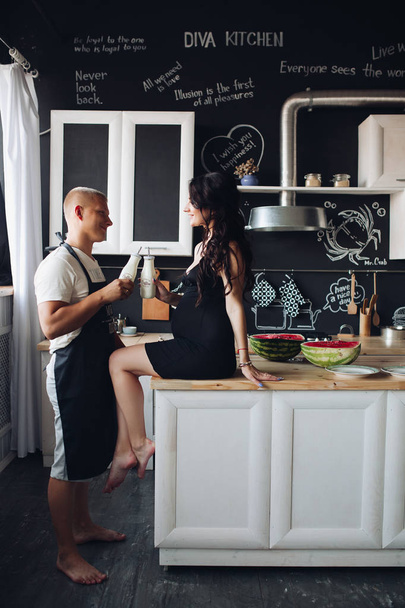 Marido cozinhar jantar para a esposa grávida adorável em casa
 - Foto, Imagem