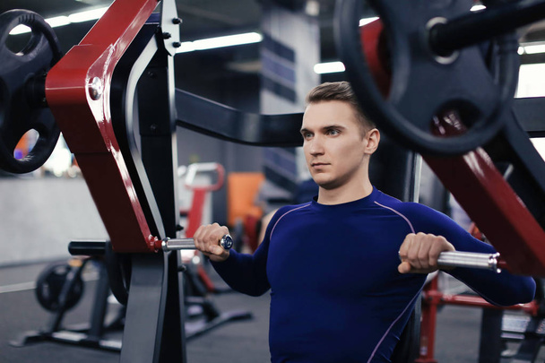 Athletic man training in modern gym - Фото, изображение