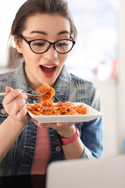 Fiatal nő evés a finom tészta beltéri - Fotó, kép