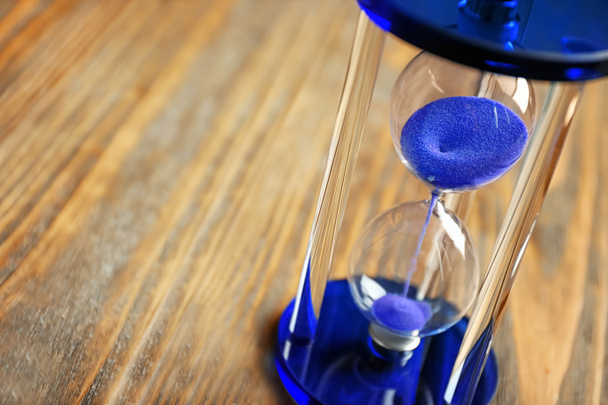 Crystal hourglass on wooden background. Time management concept - 写真・画像