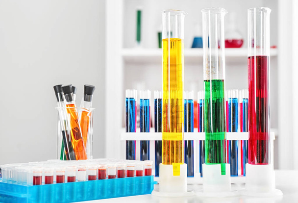 Test tubes with colorful liquids on table - Fotoğraf, Görsel