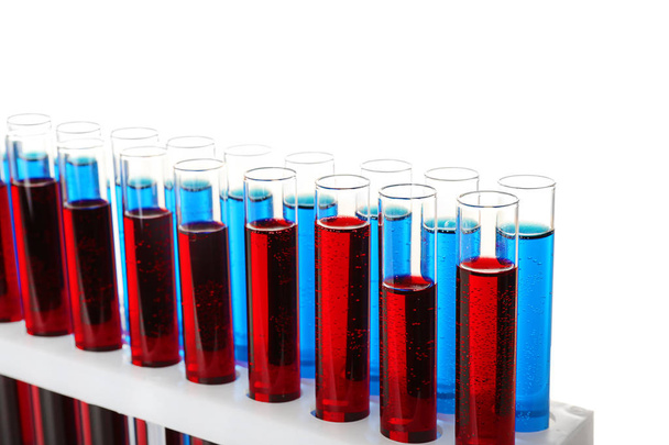 Reageerbuisjes met kleurrijke vloeistoffen in houder op witte achtergrond - Foto, afbeelding